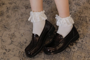 Dettaglio calzini Lolita in pizzo bianco con fiocco e mocassini marroni
