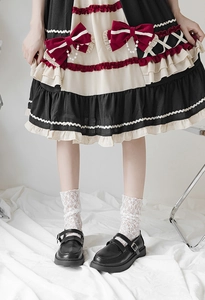 Close-up of white lace mesh socks paired with classic black Mary Jane shoes