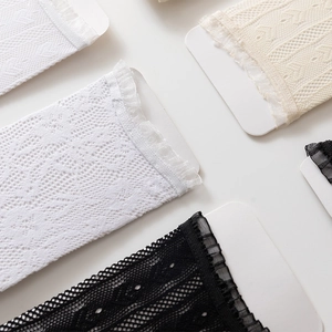 Close-up of delicate hollow lace texture and translucent pleated edges on stylish socks