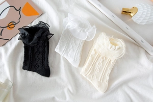 Detailed view of heart-patterned knit socks with delicate lace ruffles in three colors