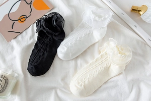 Detail of Lolita style mesh socks with lace frills and heart-shaped hollow patterns