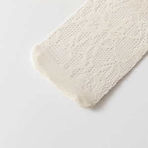 Detail of white lace sock showing intricate floral mesh and reinforced toe structure