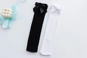 Detail of JK uniform over-knee socks with elegant bow knots in black and white