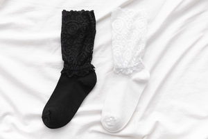 Détail de la bordure en dentelle vintage sur des chaussettes Lolita noir et blanc