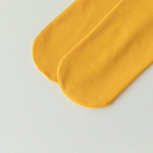 Macro shot of bright yellow ribbed velvet socks showing premium knitted texture and seams