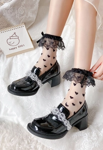 Détail de chaussettes en dentelle à cœurs et nœud avec mocassins vernis perlés