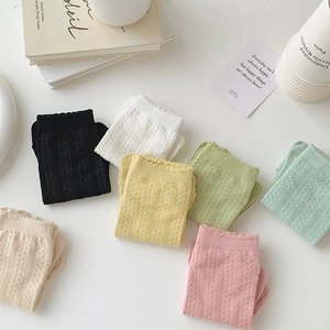 Flat lay of colorful hollow knit five-finger socks in various retro pastel shades