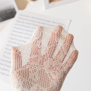 Macro detail of white lace mesh fabric showing semi-transparent floral patterns and high elasticity