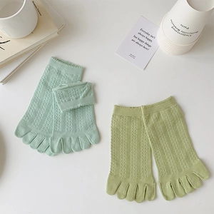 Detailed view of mint green hollow lace knit texture on breathable cotton five-finger socks