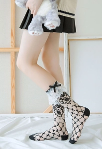 Detail von schwarzen Lolita-Spitzensocken mit weißem Rüschenrand und Seidenschleife