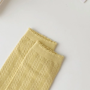 Detail of light yellow knit five-finger socks with diamond mesh and wavy edge design