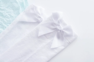 Detailed close-up of white JK uniform socks with elegant satin bow accents for women