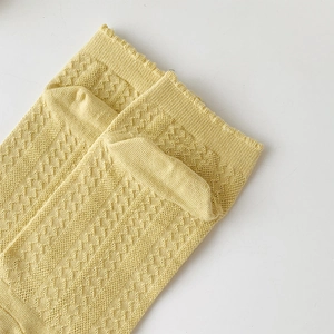 Detail of light yellow mesh hollow knit socks with breathable lattice texture design