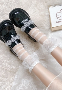 Détail de chaussettes blanches à volants et rayures avec chaussures Mary Jane noires