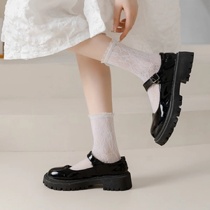 Glossy black patent leather Mary Jane shoes with thick serrated soles and lace socks