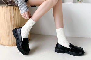 Detail of white ribbed mid-calf socks paired with black platform leather loafers in JK style