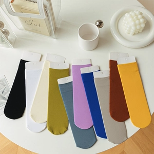 Colorful cotton mid-calf socks in ten solid colors displayed on a white minimal table
