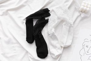 Détails de chaussettes noires et blanches avec bordure en dentelle fleurie et coton doux