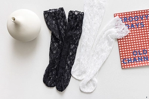Detailed view of floral lace texture on mesh crew socks in black and white colors