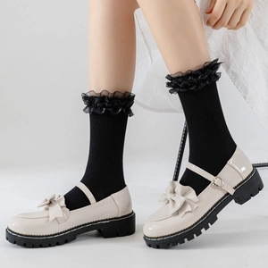 Chaussures Mary Janes crème style JK avec chaussettes noires à volants sur mannequin