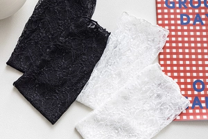 Detailed close-up of floral lace texture on vintage black and white mesh crew socks