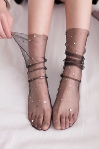 Detail of sheer black mesh socks with silver moon and star prints for a sweet summer look