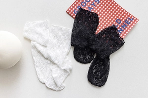 Flat lay of black and white sheer lace mesh socks with floral patterns and vintage style