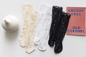 Flat lay of floral lace mesh mid-calf socks in beige, white, and black with mesh texture