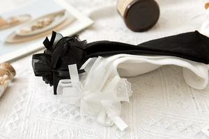 Dettaglio del fiocco in pizzo Lolita su calze di cotone bianco e nero per uniforme JK