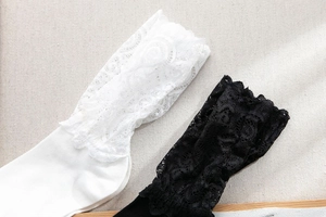 Gros plan de chaussettes en dentelle noire et blanche avec broderie florale
