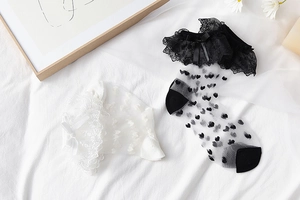 Détail de chaussettes en dentelle Lolita avec motifs de cœur et nœuds en satin