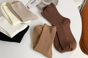 Detailed view of earth-toned cotton ribbed socks in a pile, highlighting knit textures