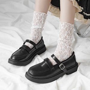 JK style black platform Mary Jane shoes with floral lace socks on white fabric background