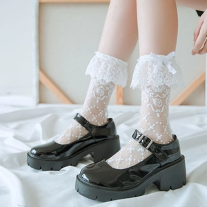 Glänzende schwarze Mary Janes mit dicker Sohle und weißen Spitzen-Schleifen-Socken im Lolita-Stil