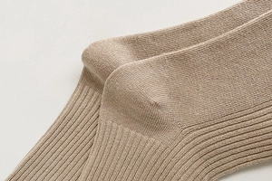 Close-up of khaki knitted socks showing ribbed texture and reinforced heel stitching