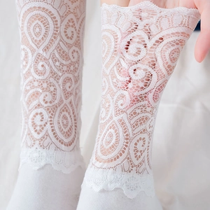 Chaussettes blanches en dentelle ajourée avec motifs floraux et bords festonnés