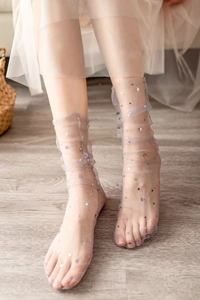 Detail of sheer grey mesh socks featuring sparkling silver star and dot sequins
