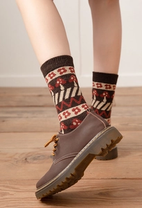Detail of thick wool socks with retro mushroom jacquard patterns and ribbed cuffs