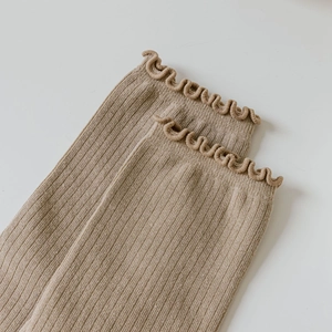 Detail of camel cotton flip-flop socks featuring ribbed texture and ruffled lettuce edges