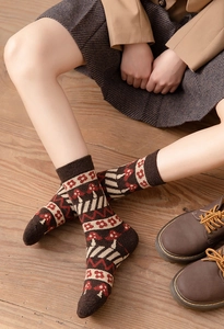 Close-up of thick wool socks featuring vintage mushroom jacquard patterns on model