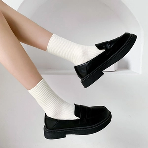 Classic black leather platform loafers paired with white mid-calf ribbed cotton socks