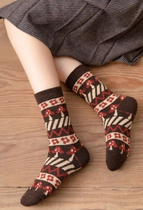Detail of thick wool socks with red mushroom pattern and vintage knit texture