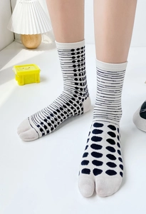 Close-up of split-toe cotton socks with stylish stripes and polka dot patterns