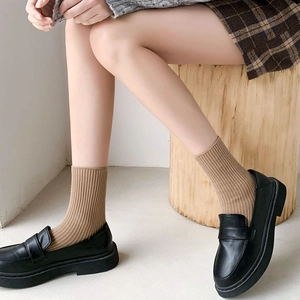 Classic khaki ribbed calf-length socks paired with black leather loafers in preppy style