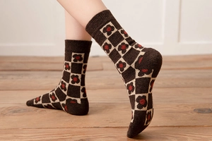 Detail of thick wool socks with brown checkerboard pattern and small flower knit texture