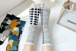 Detailed view of colorful cotton tabi socks with polka dots and abstract stripe patterns