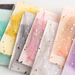 Detail of sheer mesh socks featuring gold star and moon patterns in multiple pastel colors