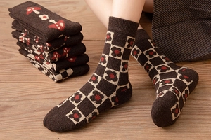 Close-up of thick wool socks with retro mushroom and floral checkerboard patterns