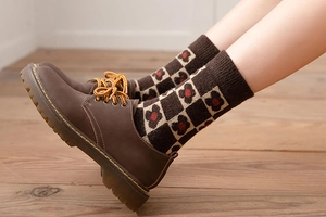 Detailed macro of vintage brown floral knit wool socks paired with leather boots