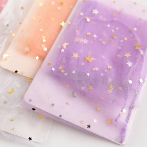 Macro detail of sheer mesh socks featuring shimmering gold and silver star moon patterns